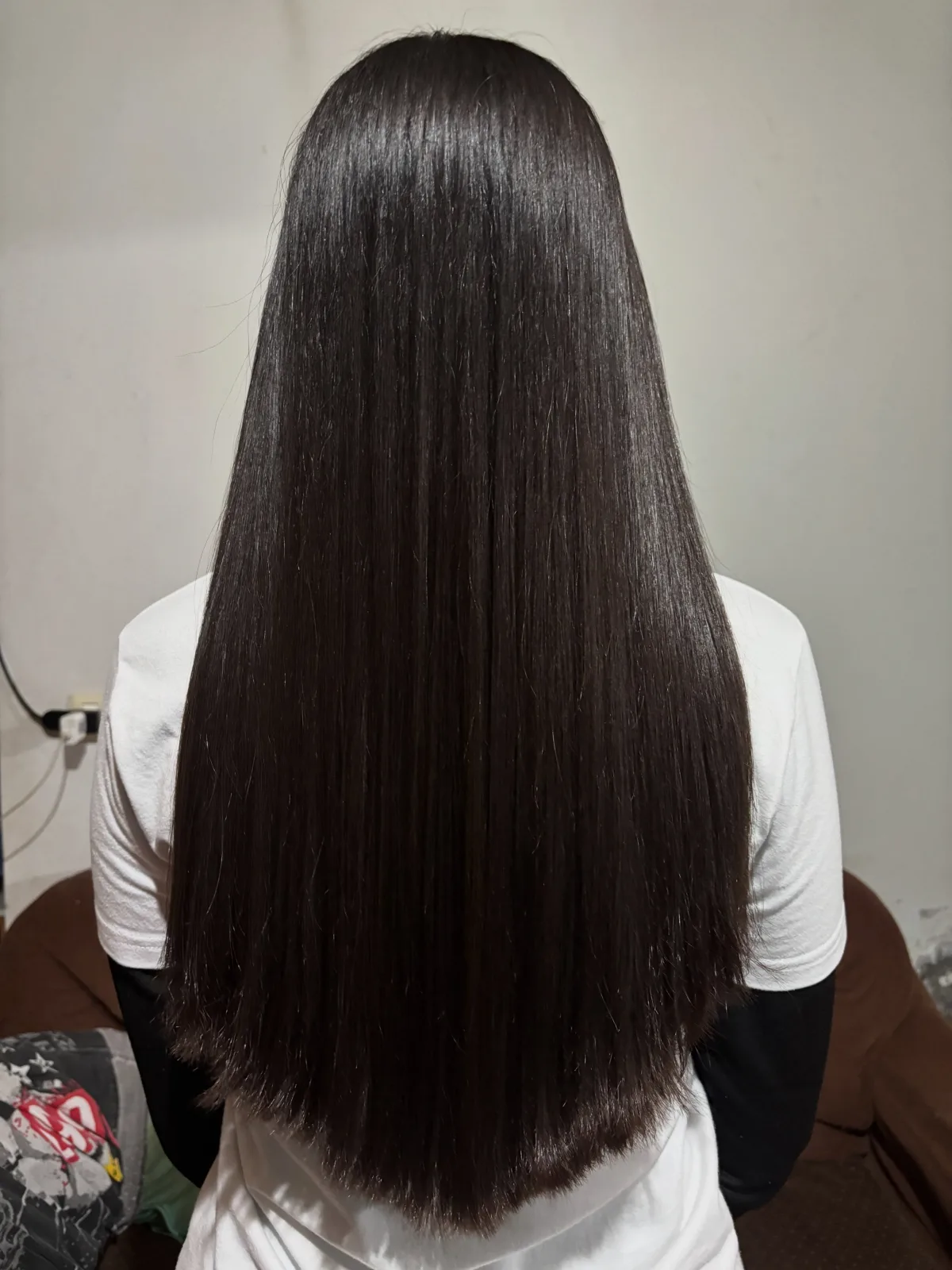 Cabello largo, oscuro, liso y brillante visto desde atrás
