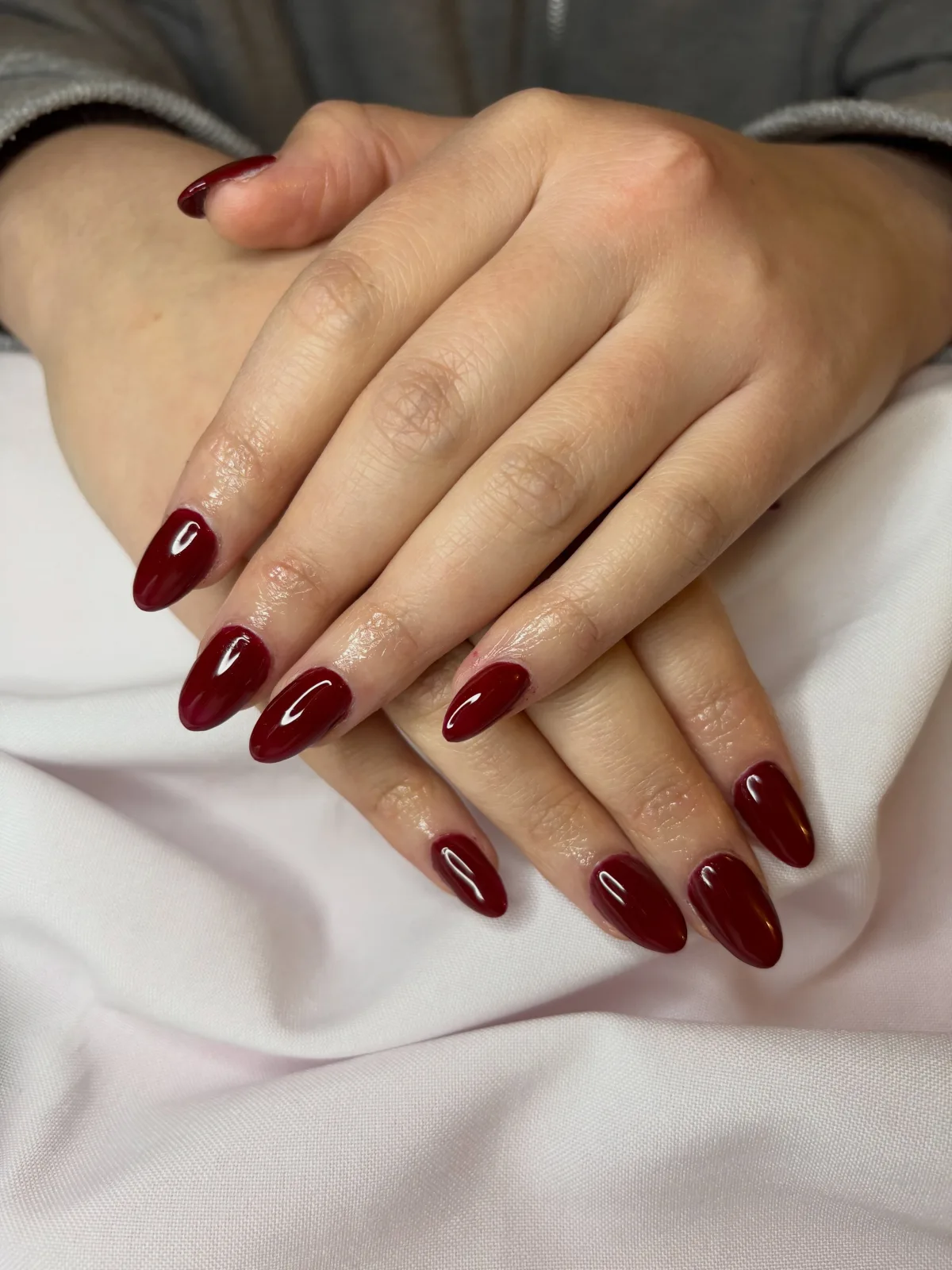 Manicure almendrada en tono borgoña brillante
