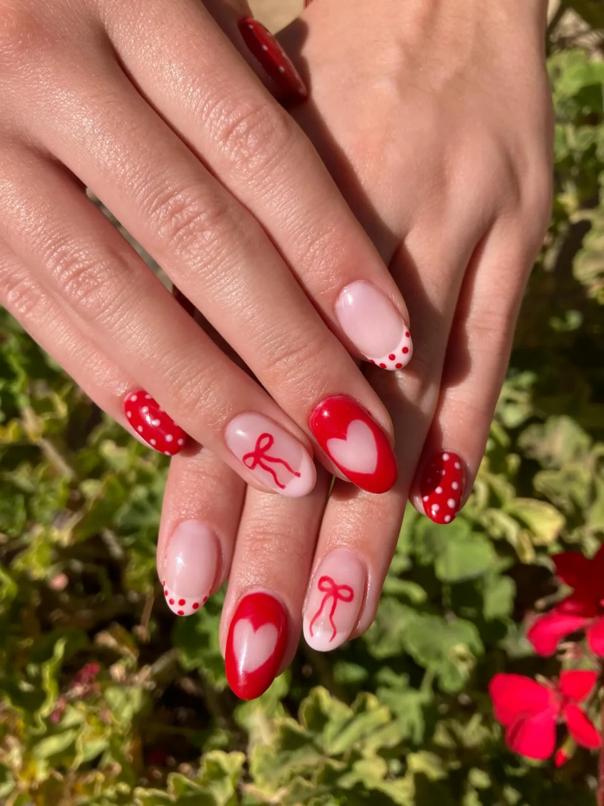 Manicure roja y rosa con corazones y lazos